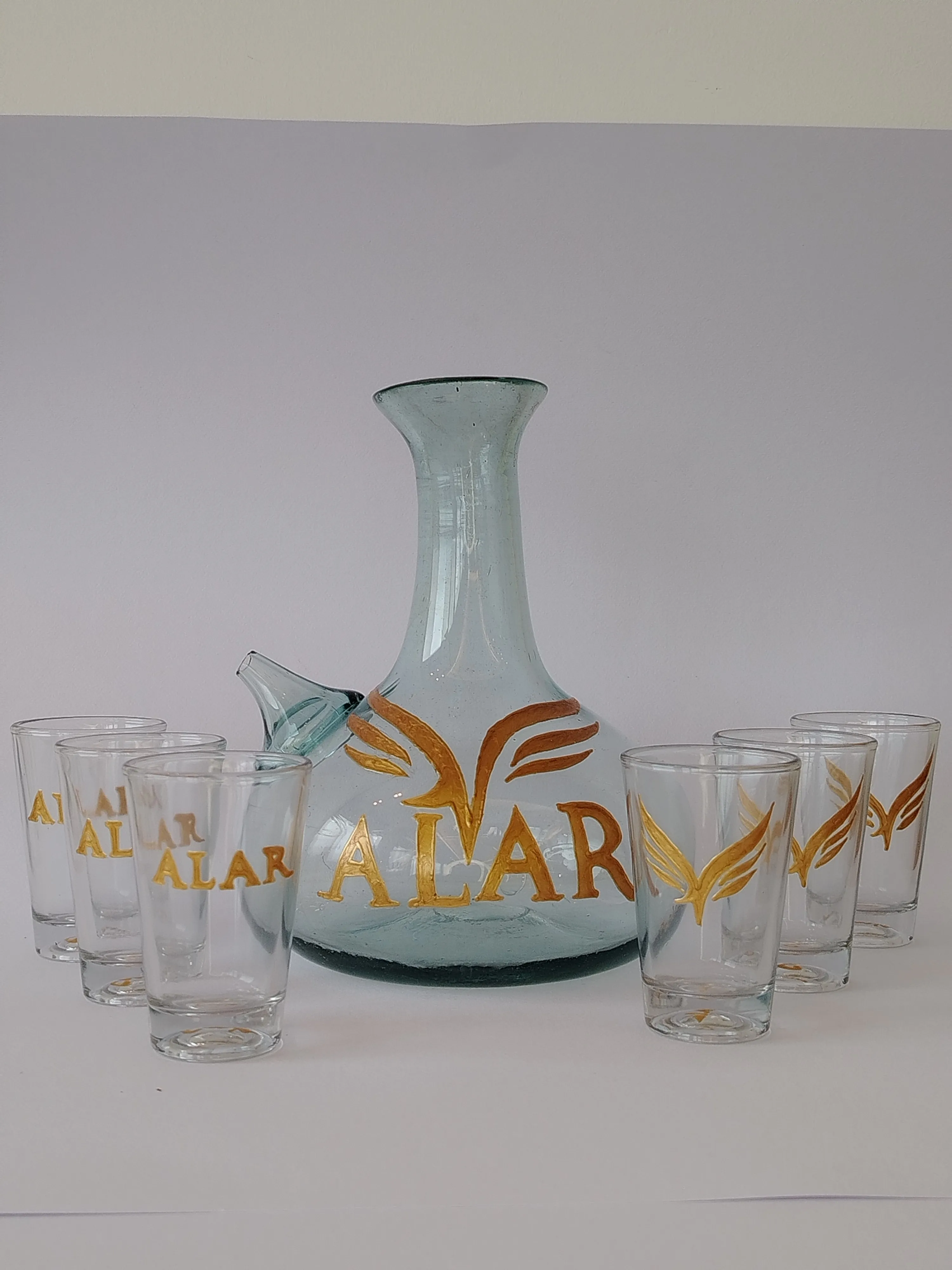 Matching set of hand-painted glass jug and tumblers with floral motifs